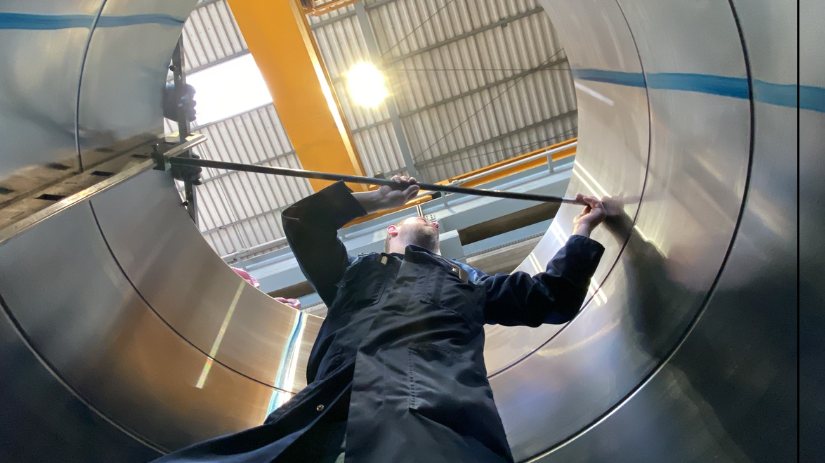 Inspector performing dimensional verification inside a large stainless steel fabrication